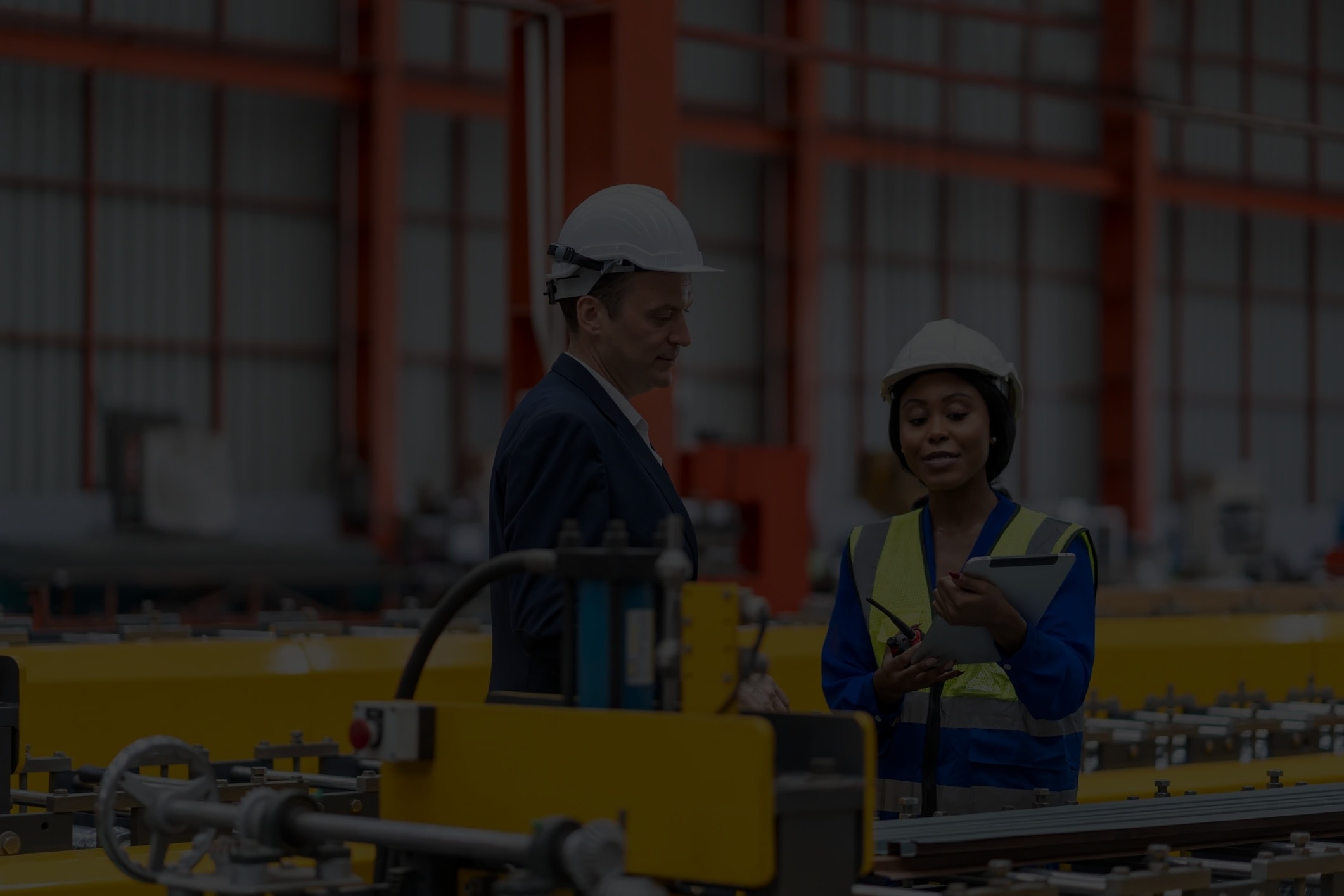 Manager e ingegnere che discutono operazioni su tablet in fabbrica